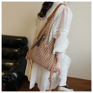 Détail d'un sac à bandoulière au crochet marron avec de longues franges et lanières fines