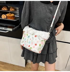 Close-up of floral drawstring bag featuring white lace trim and colorful heart prints