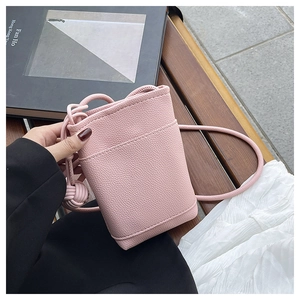 Detailed view of the pink lychee-patterned mini crossbody bag held in hand for scale