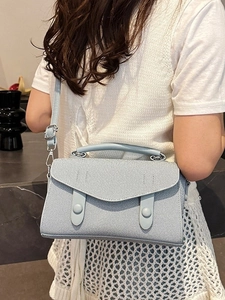 Stylish light blue denim textured crossbody bag with top handle and silver buckle