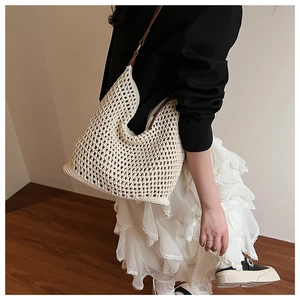 Detailed close-up of ivory hollow crochet tote with brown leather shoulder straps