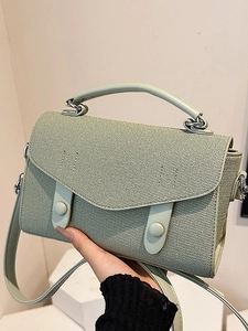 Sage green crossbody square bag with fabric texture and leather handle details
