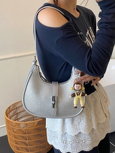 Silver pebbled leather hobo bag with metal buckle and cartoon charm accessory