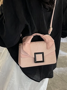 Pink snake pattern crossbody bag with square black buckle shown in a side view