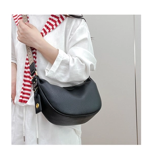Detail of black pebbled leather crescent bag with stylish woven shoulder strap