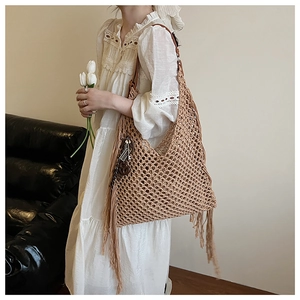 Détail du sac cabas en tricot ajouré vintage avec franges et breloque musicale