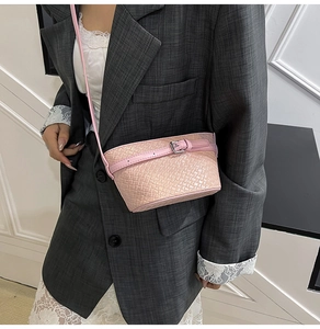 Dettaglio di una borsa a tracolla rosa chiaro con trama intrecciata e fibbia in argento