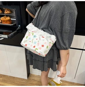 Detail of floral crossbody bag with lace trim shown in a cozy kitchen setting
