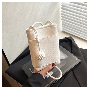 Close-up of a white lychee grain bucket bag featuring a unique braided rope knot design