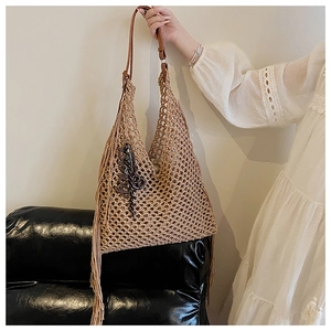 Détail du sac cabas en tricot ajouré avec de longues franges et anse en cuir