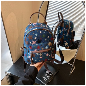 Detail of star-embroidered denim mini backpack with leather handles and zip pockets