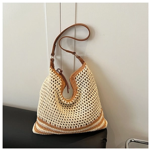 Detail of bohemian hollow-out crochet tote with brown leather strap and striped accents