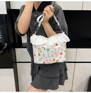 Detail of floral canvas bag with white lace ruffle edge and detachable printed shoulder strap
