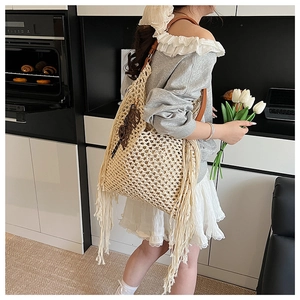 Détail du sac cabas en maille ajourée avec franges crème et breloque Blossom en cuir