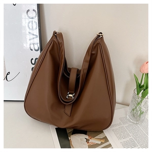 Close-up of brown large tote bag with H-shaped metal buckle and smooth leather finish