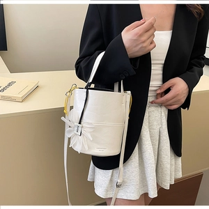 Chic white bucket bag with floral charm and adjustable strap for urban styling