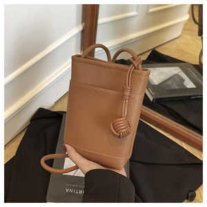 Detail of caramel lychee textured mini crossbody bag with unique knotted strap detail