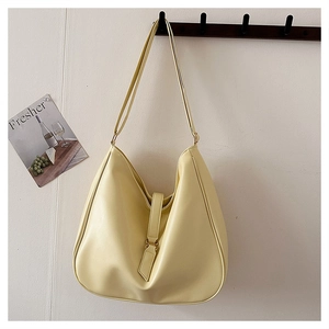 Detail view of large cream yellow hobo bag with buckled strap and fine leather texture