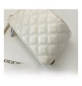 Detailed macro view of white quilted leather texture and a branded metal zipper slider