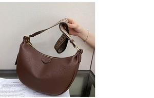 Detail of a brown lychee pattern leather dumpling bag with woven wide shoulder strap