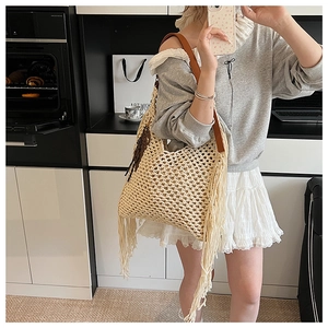 Détail du sac tricoté bohème avec texture ajourée et longues franges sur le côté