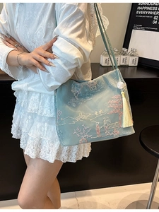 Light blue satin bucket bag with traditional embroidery and pearl tassel detail