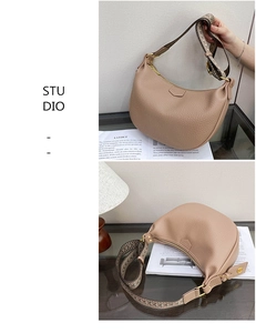 Detail of beige hobo bag with lychee grain leather and colorful woven wide strap
