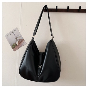 Detail showing the adjustable strap and gold buckle on a black minimalist tote bag