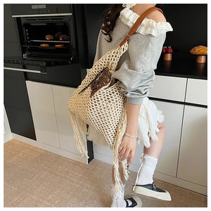 Détail du sac au crochet crème avec de longues franges et une bandoulière en cuir brun