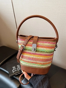 Rainbow woven bucket bag with brown leather straps and metal twist lock for beach vacations