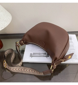 Detail of dark brown pebble leather hobo bag with wide geometric pattern strap