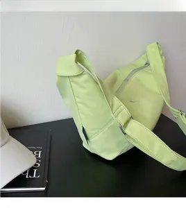 Detail der hellgrünen Halbmondtasche mit glattem, verstellbarem Nylon-Schultergurt
