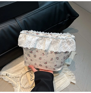 Detail view of floral canvas bag with elegant white lace trim and delicate rose patterns