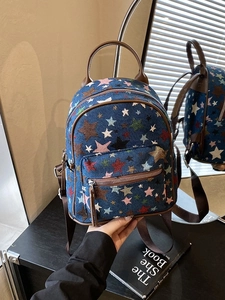 Mini star print backpack with brown leather trim and mirror reflection view