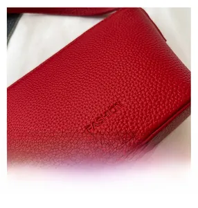 Nahaufnahme einer roten Leder-Eimertasche mit Lychee-Muster und geprägtem Schriftzug