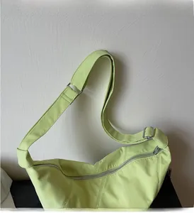 Detail der mintgrünen Dumpling-Tasche mit glatter Nylon-Textur und silbernem Reißverschluss