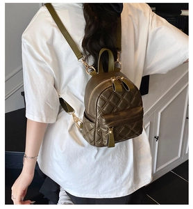 Model view of an olive green quilted mini backpack with elegant gold hardware