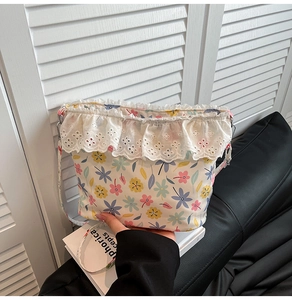 Close-up of floral crossbody bag featuring colorful prints and white lace trim detail