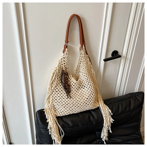 Vue détaillée du sac en maille beige avec bandoulière en cuir marron et franges latérales