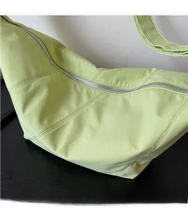 Nahaufnahme der avocadogrünen Halbmondtasche mit Rautensteppung und Silber-Reißverschluss