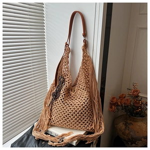 Détail d'un sac bandoulière bohème en tricot ajouré avec franges et cuir