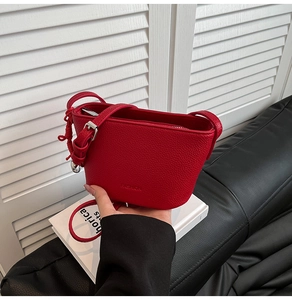 Detail der roten Beuteltasche aus Leder mit Litschimuster und silbernen Metallteilen