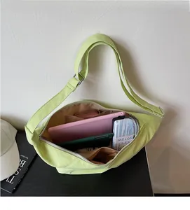 Geräumiger Innenraum der mintgrünen Halbmond-Tasche mit Tablet und Alltagsutensilien
