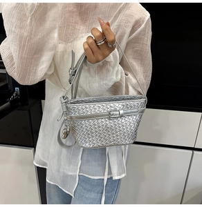 Dettaglio della mini borsa a secchiello argento intrecciata con ciondolo a cuore