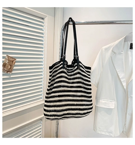 Detail of knit tote bag with black and white stripes and crochet texture on hanger