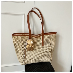 Détail du sac cabas en paille avec lanières en cuir marron et pendentif ours en peluche