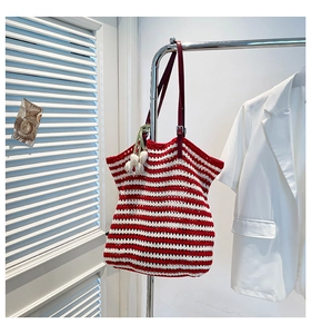 Detail of red and white striped crochet tote bag with leather straps and tulip charm