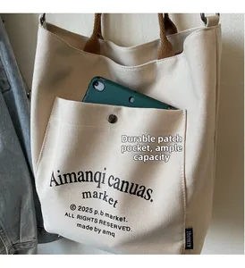 Detail view of canvas tote bag showing durable front pocket and spacious interior capacity