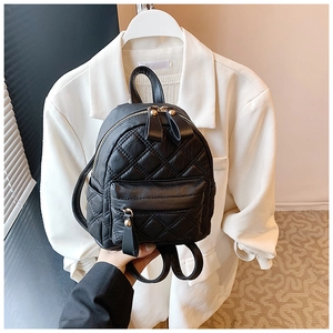 Detailed view of black quilted mini backpack with gold hardware and premium texture finish