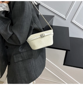Vista dettagliata della borsa quadrata bianco panna con trama intrecciata e cinturino metallico